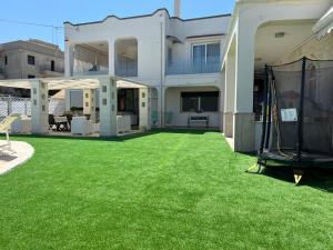 una casa con un cortile con erba verde di Casa de lidzia2 a Cisternino