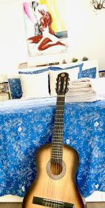 a guitar sitting on top of a bed at Zenit Olhao Bed & Breakfast in Olhão
