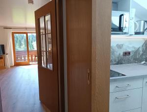 a kitchen with a wooden door and a counter top at Apartments im Jagdhof in Fischen +16 photos