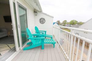 two blue chairs sitting on the front porch of a house at Sojourn The Ocean Breeze in Virginia Beach in Virginia Beach