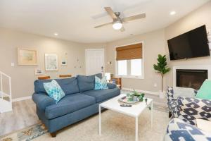 a living room with a blue couch and a tv at Sojourn The Ocean Breeze in Virginia Beach in Virginia Beach