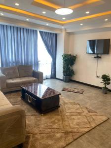 uma sala de estar com um sofá e uma televisão em Buhe Plaza Guest House em Addis Ababa