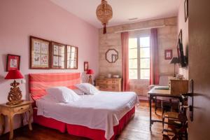 a bedroom with a bed and a desk and a window at HOTEL et APPARTEMENTS DOMAINE DES CLOS - Teritoria in Beaucaire