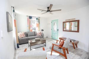 uma sala de estar com um sofá e uma ventoinha de tecto em Sojourn Coastal Cottage 3 BR em Norfolk