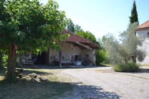 una casa de piedra con un árbol delante en Al Bioule - Maison climatisée avec piscine, en Penne-dʼAgenais