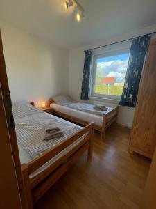1 Schlafzimmer mit 2 Betten und einem großen Fenster in der Unterkunft Ostseeblick - b44574 in Holnishof