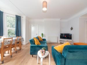 a living room with two blue couches and a table at Elegant bright flat free parking Pass the Keys in Kingston upon Thames