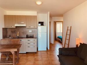 a kitchen with a refrigerator and a table and a couch at Punta di Mare in Linguizzetta