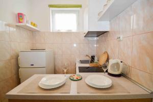 een kleine keuken met twee borden en wijnglazen op een aanrecht bij Apartments in Pula/Istrien 10950 in Veruda