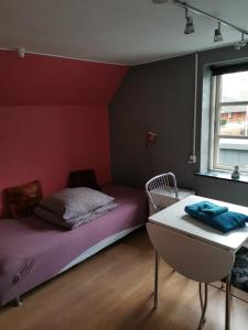 - une chambre avec un lit, une chaise et une fenêtre dans l'établissement Skolevænget 35, à Skjern