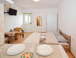 een kamer met een bed en een tafel met borden erop bij Apartments in Pula/Istrien 10950 in Veruda
