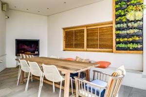 una sala da pranzo con tavolo e sedie in legno di Oranjezicht Heritage Home a Città del Capo