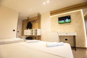 a bedroom with two beds and a tv on the wall at Hotel Klebrido in Durrës