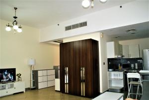 a room with a large wooden door in a kitchen at Studio Apartment - Cozy, Very Accessible and so near to Train Station in Dubai