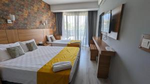 ein Hotelzimmer mit 2 Betten und einem TV in der Unterkunft Antalya Ramona in Antalya