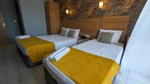 duas camas num quarto de hotel com lençóis amarelos em Antalya Ramona em Antália