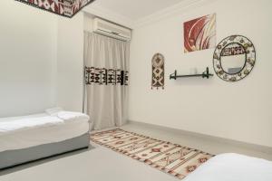 a white room with two beds and a mirror at Sands Inn Hostel in Riyadh