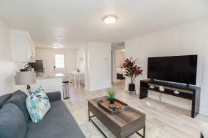 a living room with a couch and a tv at Sojourn Beachside Hideaway 2 BR in Norfolk