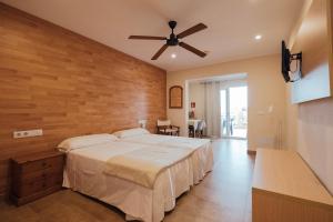 Schlafzimmer mit einem Bett und einem Deckenventilator in der Unterkunft Apartamentos Blancala in Cala Blanca