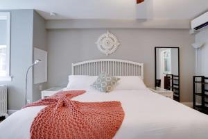 um quarto com uma cama branca e um cobertor vermelho em Sojourn 1 BR with private patio em Washington