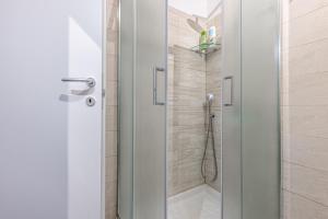 W łazience znajduje się prysznic ze szklanymi drzwiami. w obiekcie Buenos Aires 35 w Mediolanie