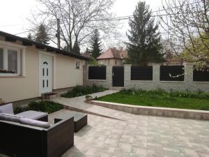 een achtertuin met een stenen patio en een huis bij Garden Home in Törökbálint