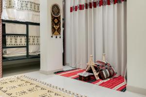 Zimmer mit weißen Vorhängen und einem roten Teppich in der Unterkunft Sands Inn Hostel in Riad