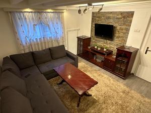 een woonkamer met een bank en een salontafel bij Guesthouse Mema in Sarajevo