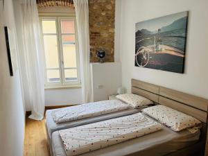 een slaapkamer met 2 bedden en een raam bij Piccolo Palazzo Vintage in San Felice del Benaco