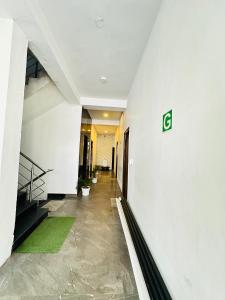 um corredor de um edifício com um sinal verde na parede em Shivjot hotel em Kharar