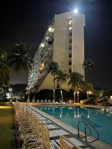 a tall building with a swimming pool at night at Seaview Retreat -Regency Tg Tuan Beach Resort, Port Dickson, Malaysia in Port Dickson