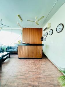 a living room with clocks on the wall and a counter at Shivjot hotel in Kharar