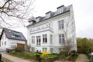 a large white building with windows on a street at Perfect Holiday Homes Near Amager Beach in Copenhagen