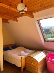 Villa Pandora - Zakopane Centrum في زاكوباني: غرفة نوم بها سرير ونافذة