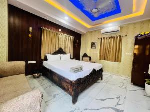 a bedroom with a large bed and a couch at PAGDANDI VILLA BY ALOHA in Udaipur
