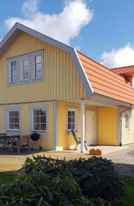 een geel huis met een oranje dak en een patio bij Gula huset in Göteborg