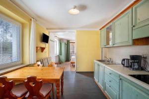 a kitchen with green cabinets and a wooden table at Silbernagl direkter Blick zum See in Issengo +17 photos