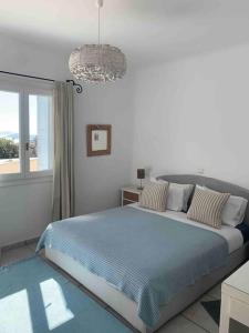 een witte slaapkamer met een groot bed en een raam bij Nafsika 4Bedroom Sea View House in Mykonos-stad