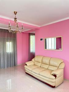a living room with pink walls and a couch at LaoVardi Hostel in Gori