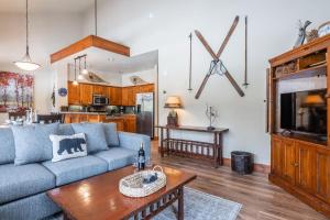 a living room with a blue couch and a table at Cabins 24 in Mammoth Lakes