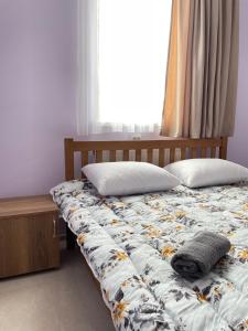 1 cama con 2 almohadas y ventana en LaoVardi Hostel, en Gori