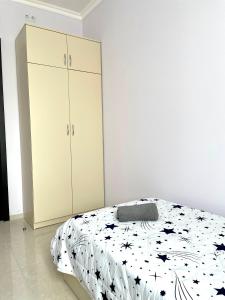 a white bedroom with a bed and a cabinet at LaoVardi Hostel in Gori