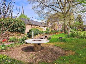 a picnic table in a garden with a church at Schloss Hilbringen Gesindewohnungen in Merzig