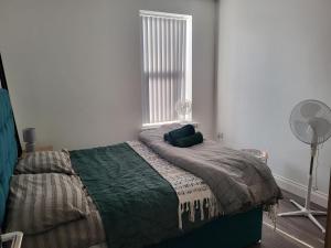 1 dormitorio con 1 cama con ventilador y ventana en 1 Bed Flat, Fibre Broadband, New, Washer Dryer, 10 mins from city centre, en Dartford