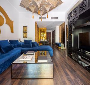 a living room with a blue couch and a table at Frank Porter - Reehan 5 in Dubai
