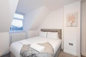 a white bedroom with a large bed with white pillows at Beautiful Cottage in Durham with Pool Table in Durham