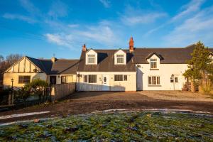 uma grande casa branca com um telhado preto em Beautiful Cottage in Durham with Pool Table em Durham