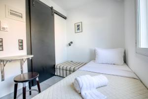 a small room with two beds and a stool at Anais - Solo traveller rooftop in Athens