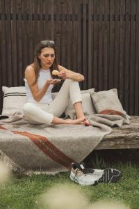 a woman sitting on a couch eating a hot dog at Schönherr Haus in Neustift im Stubaital