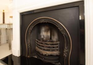 a black fireplace with a gold frame in a living room at Beautiful Victorian Coastal Holiday Home in Kent